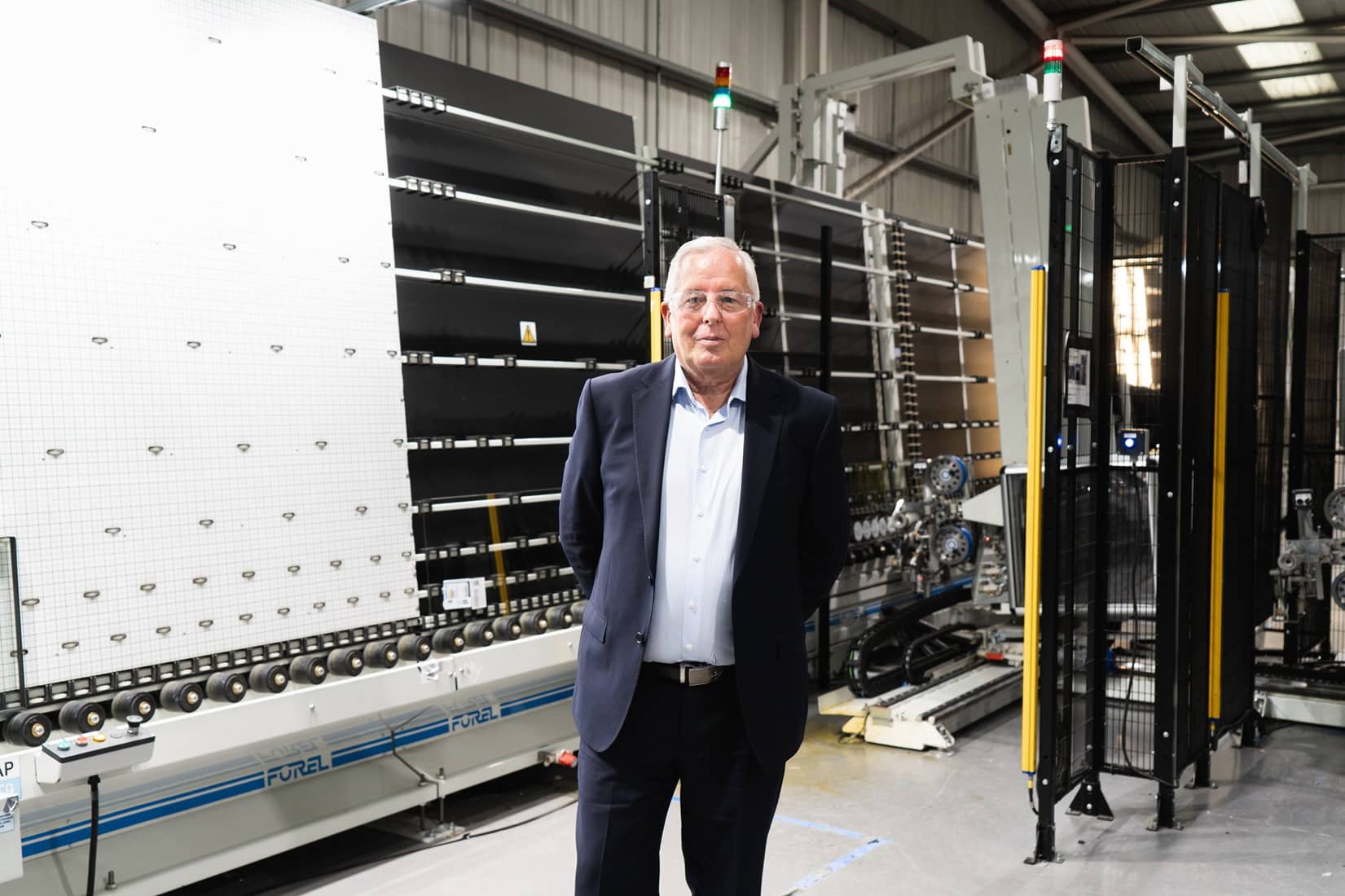 A man standing in front of the machines manufacturing window spacer bar in the factory of Edgetech.